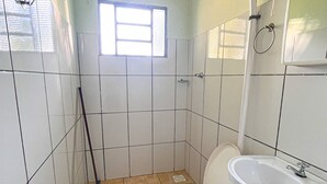Un baño pequeño con inodoro, lavamanos y ventana.