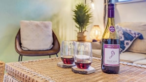 Eine Flasche Barefoot Pinot Noir auf einem gewebten Tisch, zusammen mit zwei mit Wein gefüllten Gläsern.