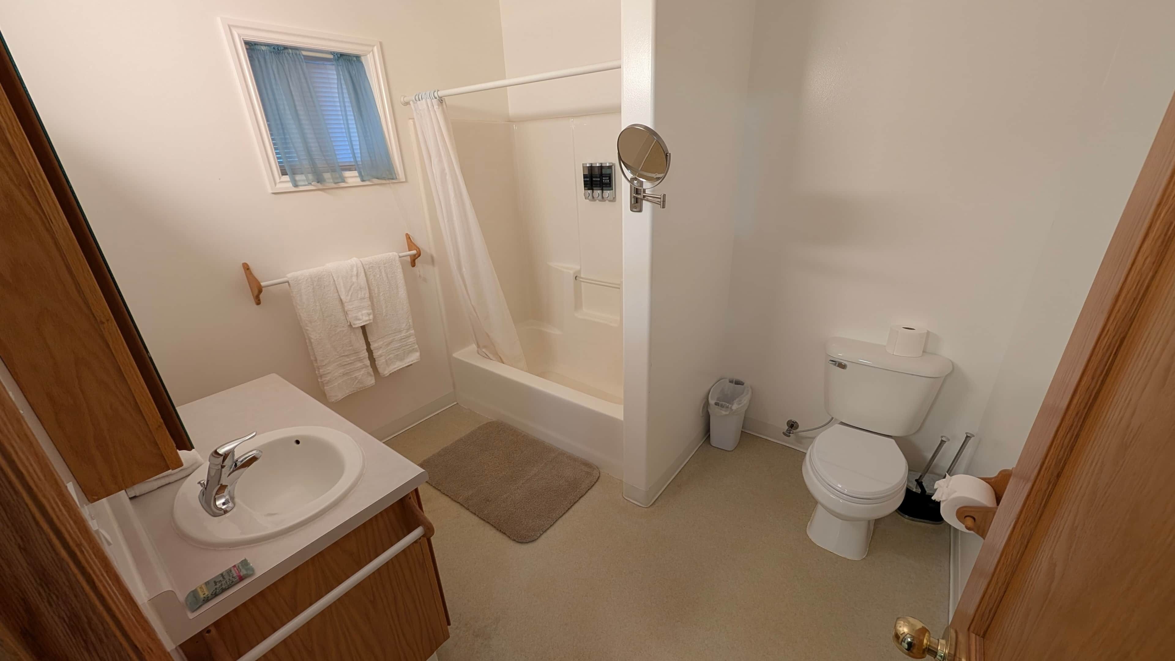 A bathroom with a bathtub, toilet, and sink.