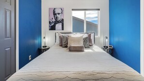 A hotel room with a bed, a window, and a painting on the wall. - Interstellar Villa with 180° Mountain Range Views (Colorado Springs)