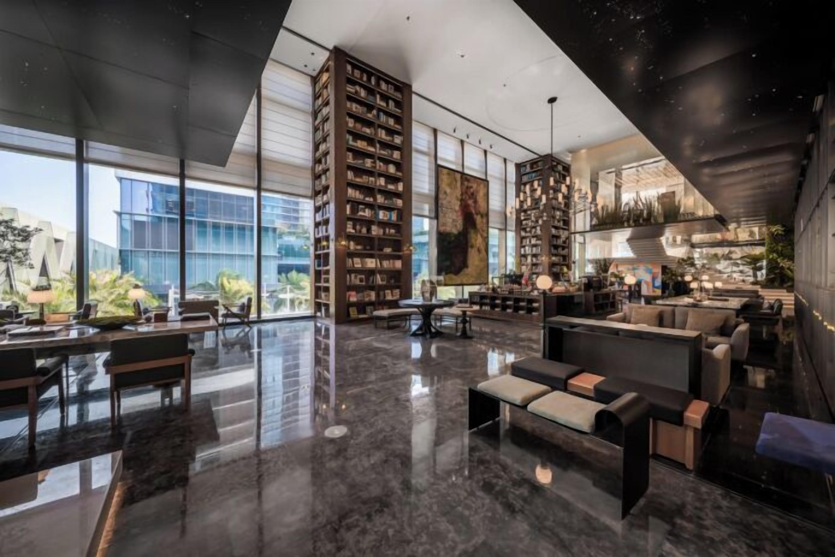 A spacious lobby with a high ceiling, large windows, and a modern design.
