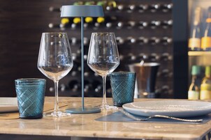Eine Bar mit zwei Weingläsern und einem kleinen blauen Glas auf einer Marmorplatte.