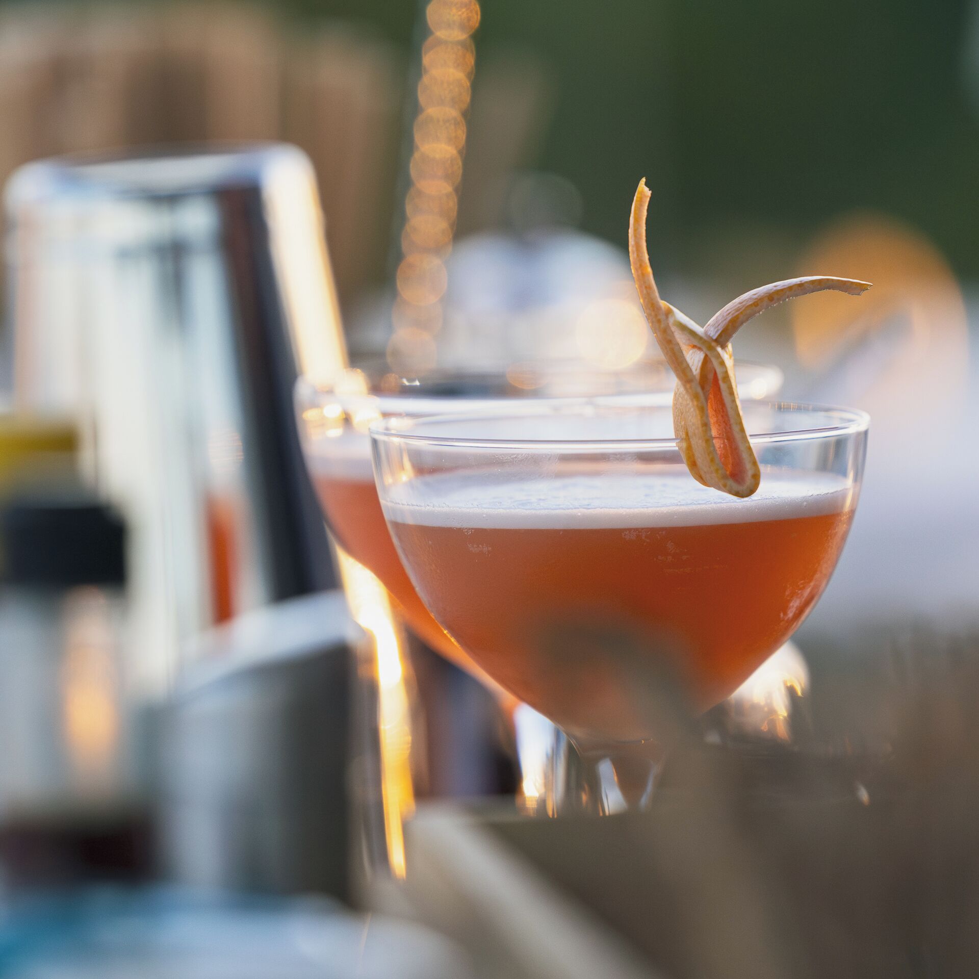 A bar setting with two cocktail glasses, one with a garnish.