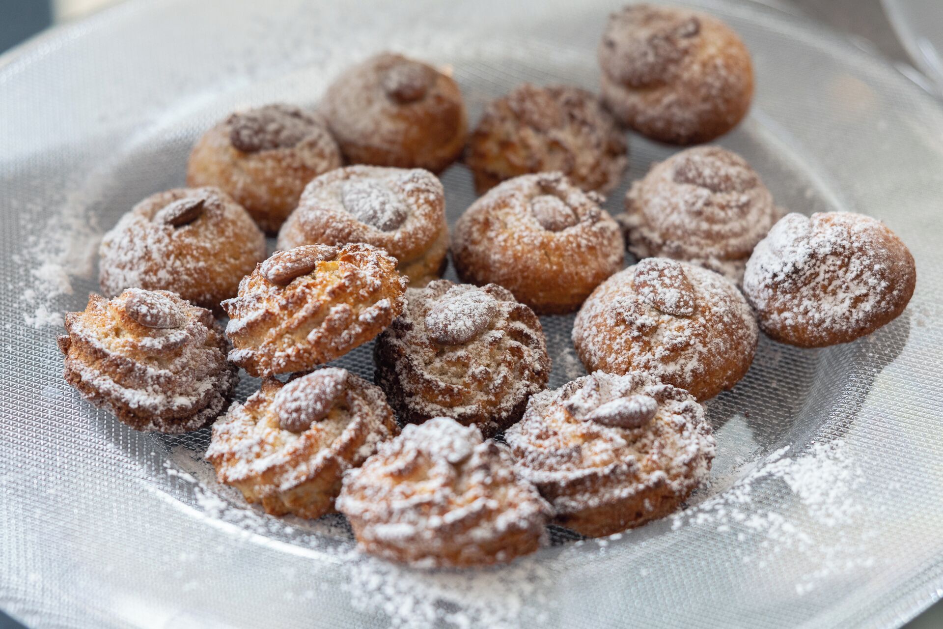 A tray of round pastries dusted with powdered sugar.