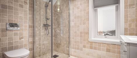 Ein modernes Badezimmer mit einer Duschkabine, einer Toilette und einem Fenster mit Blick.