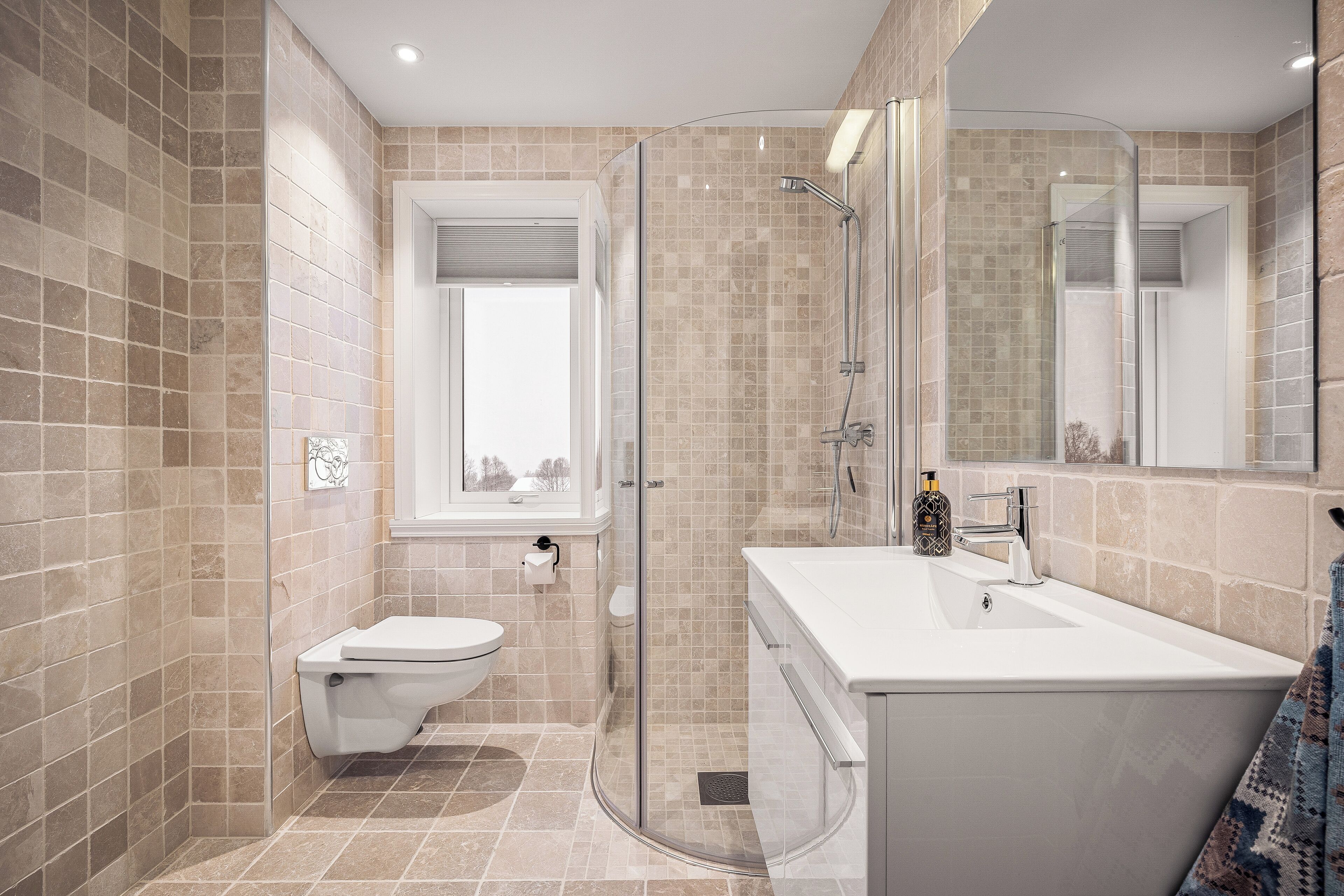 Une salle de bain moderne avec une douche à parois de verre, un lavabo blanc et des toilettes.