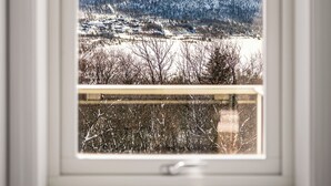 A window with a view of snow-covered mountains and a clear sky. - Gullstein (Hol)