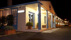 Un edificio con recepción, escalera y aparcamiento de noche.