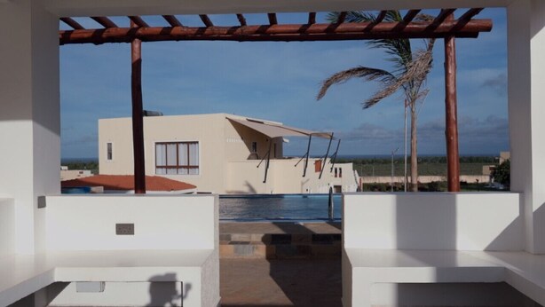An outdoor seating area with a view of a building and a pool. - Seaside Bliss Vipingo (Kilifi)