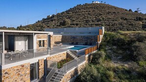A stone building with a pool, outdoor seating, and a view of a hill. - Kōa Villa I, idyll Seaview Near Beach by etouri (Heraklion)