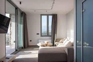 Relax in style with a comfortable seating area, flat-screen TV, and expansive balcony views.
