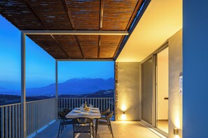 Enjoy a serene dining experience with a view of the surrounding mountains from this balcony.