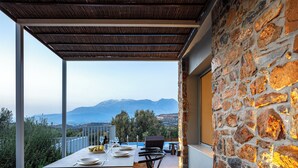 A terrace with a table set for dining, overlooking a mountainous landscape. - Kōa Villa II, Stylish villa Near Beach by etouri (Heraklion)