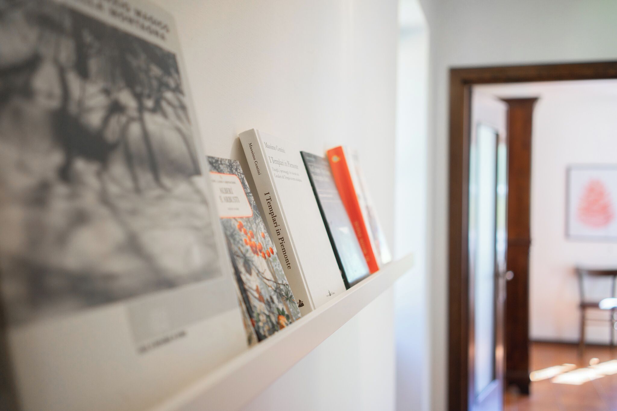 Une bibliothèque remplie de livres et un tableau encadré accroché au mur.