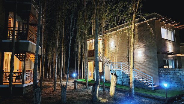 A two-story building with a wooden exterior, a staircase, and a balcony. - The Unalome Resort (Leh)