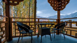 A wooden gazebo with a table and two chairs, overlooking a mountainous landscape. - The Unalome Resort (Leh)