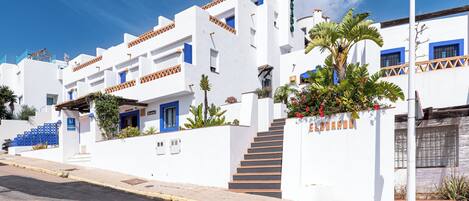 A white building with blue accents and a sign reading "Hostal".