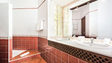 Un baño con dos lavamanos, ducha y un espejo grande.