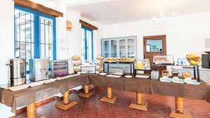 A buffet setup with various food stations, a coffee machine, and a fruit bowl. - El Dorado San Jose (San José)