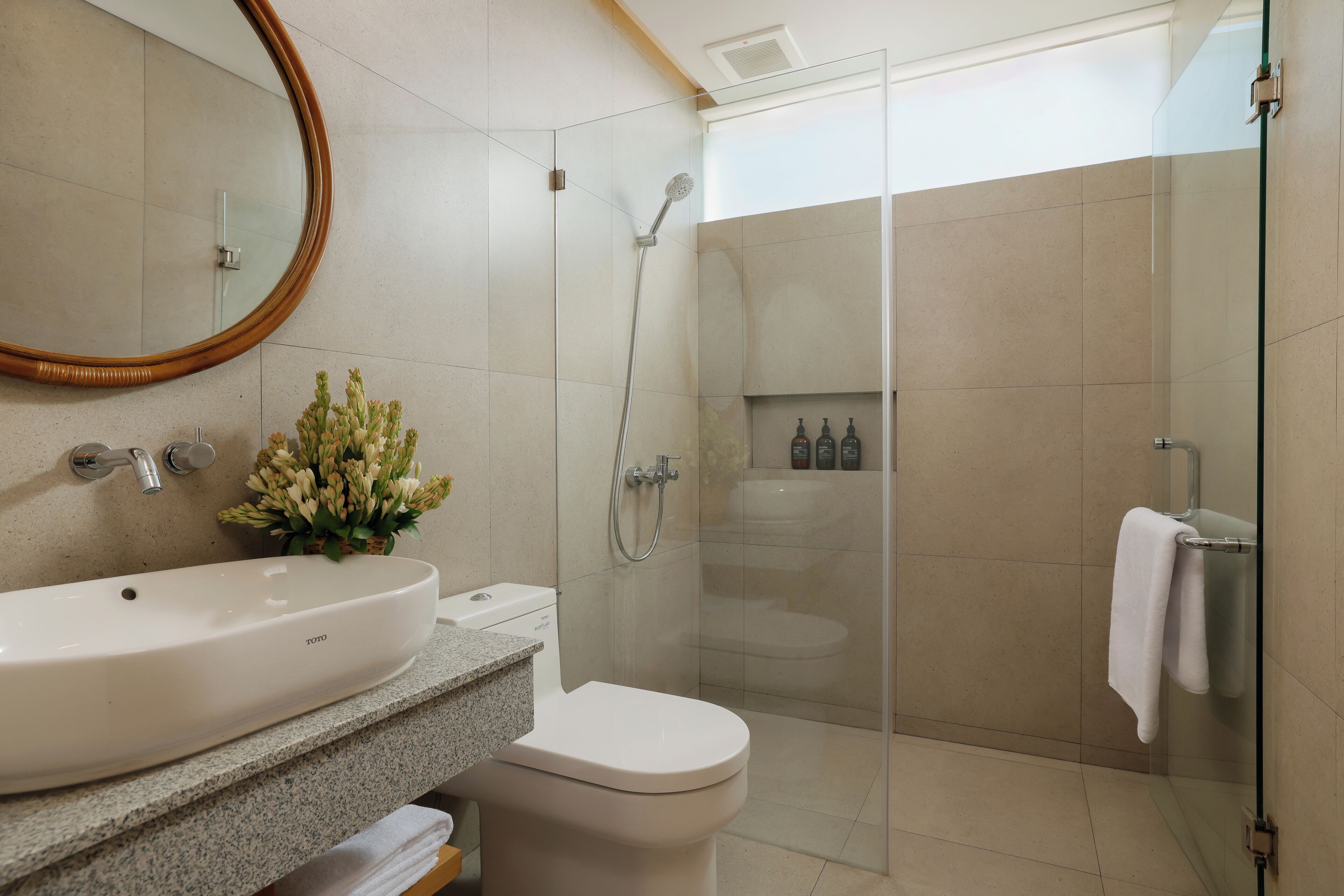 A modern bathroom with a white sink, toilet, and shower.