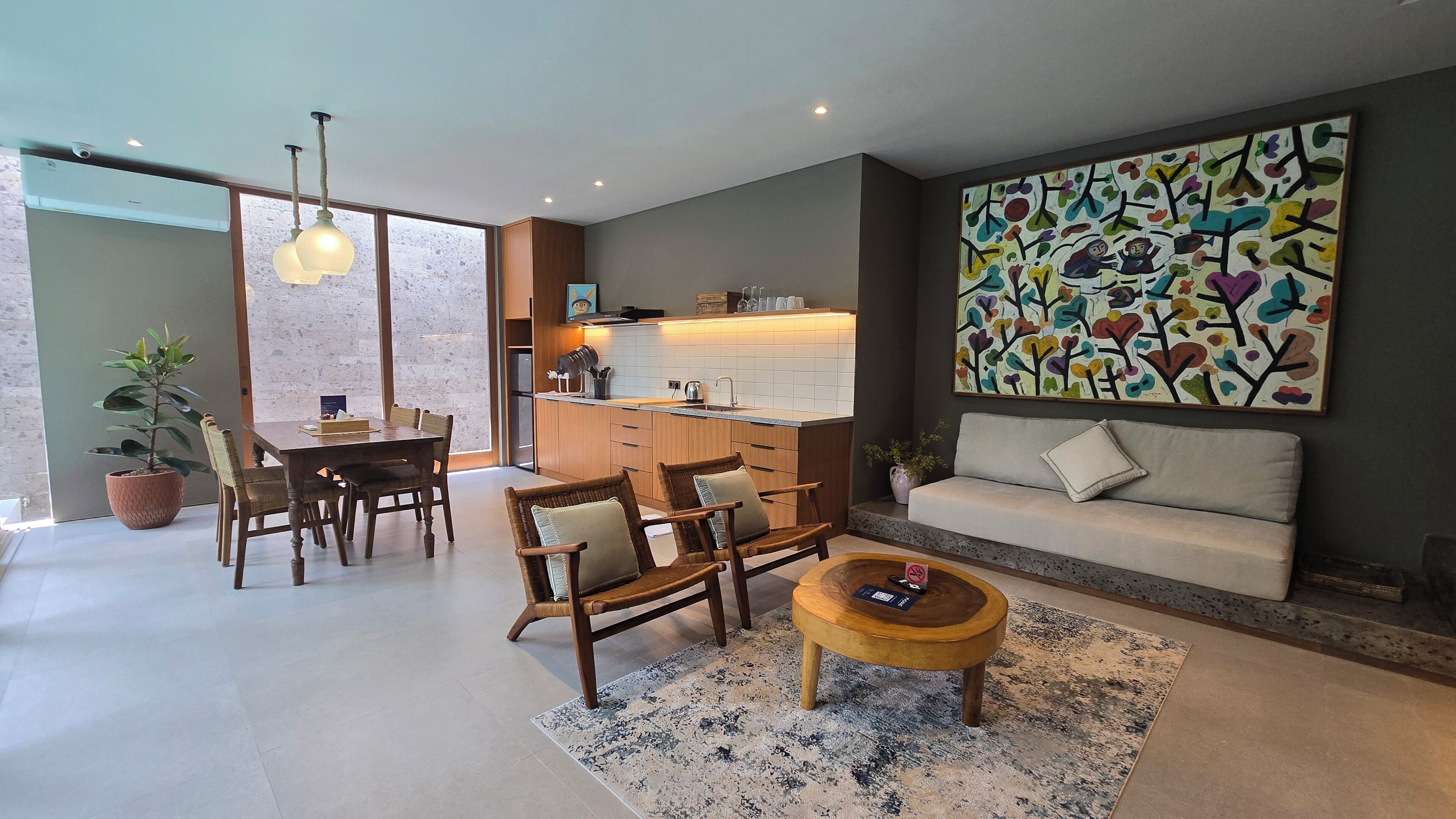 A modern living room with a sofa, dining table, chairs, and a coffee table.