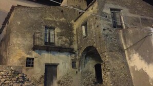 Un vieux bâtiment en pierre doté d’un balcon et d’une porte d’entrée en arc de cercle.