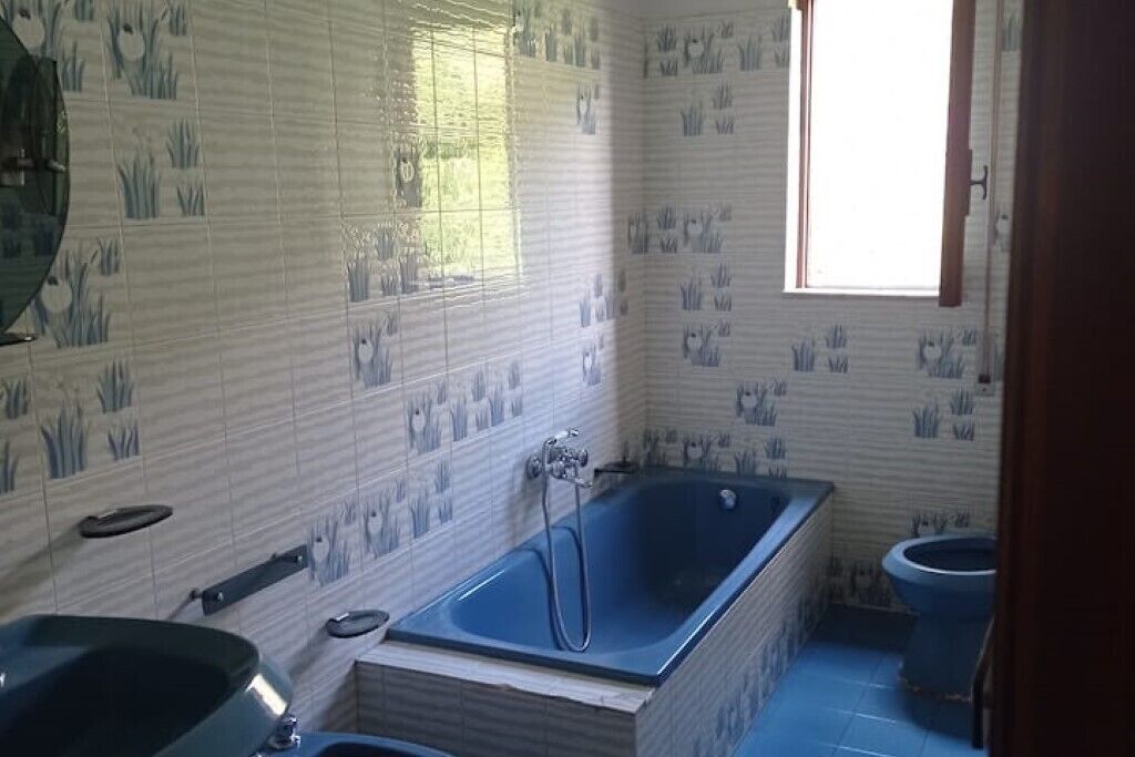 Een badkamer met een bad, wastafel en toilet.