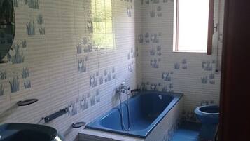 Een badkamer met een bad, wastafel en toilet.