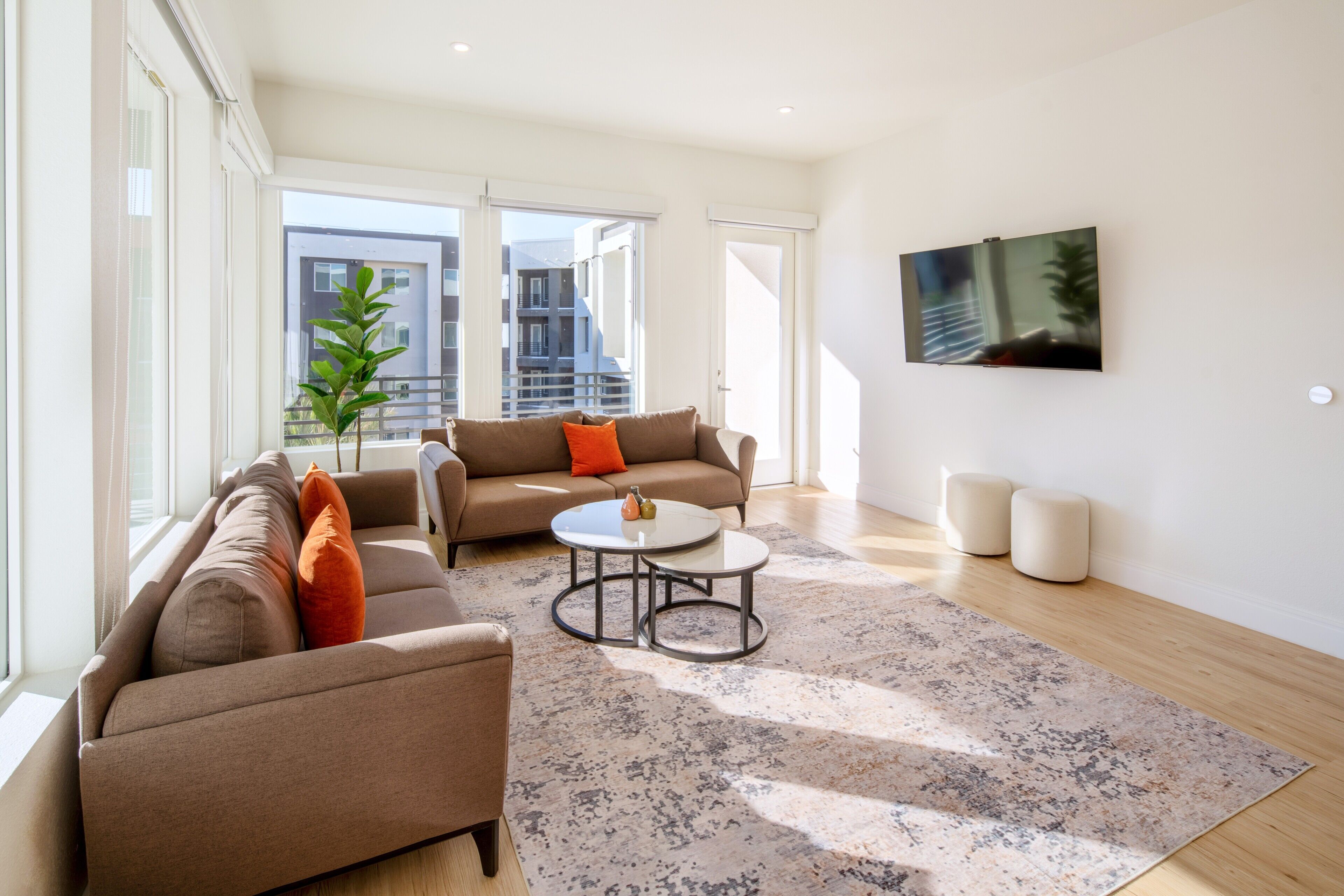 A modern living room with a sofa, a coffee table, and a TV mounted on the wall.
