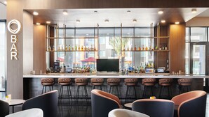 Un espace bar moderne doté d’un comptoir, de sièges et d’une grande fenêtre.