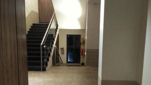 Um corredor com escadas que levam a um patamar.