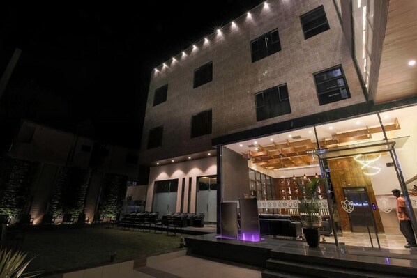 Un hotel moderno con una amplia zona de estar al aire libre, una recepción y una entrada bien iluminada.