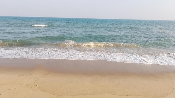 Una playa con aguas transparentes y una orilla arenosa.