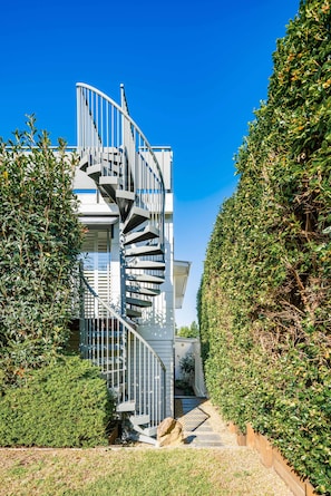 A modern building with a spiral staircase leading to a balcony.