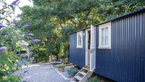 A small, single-story cabin with a wooden staircase leading to a door.