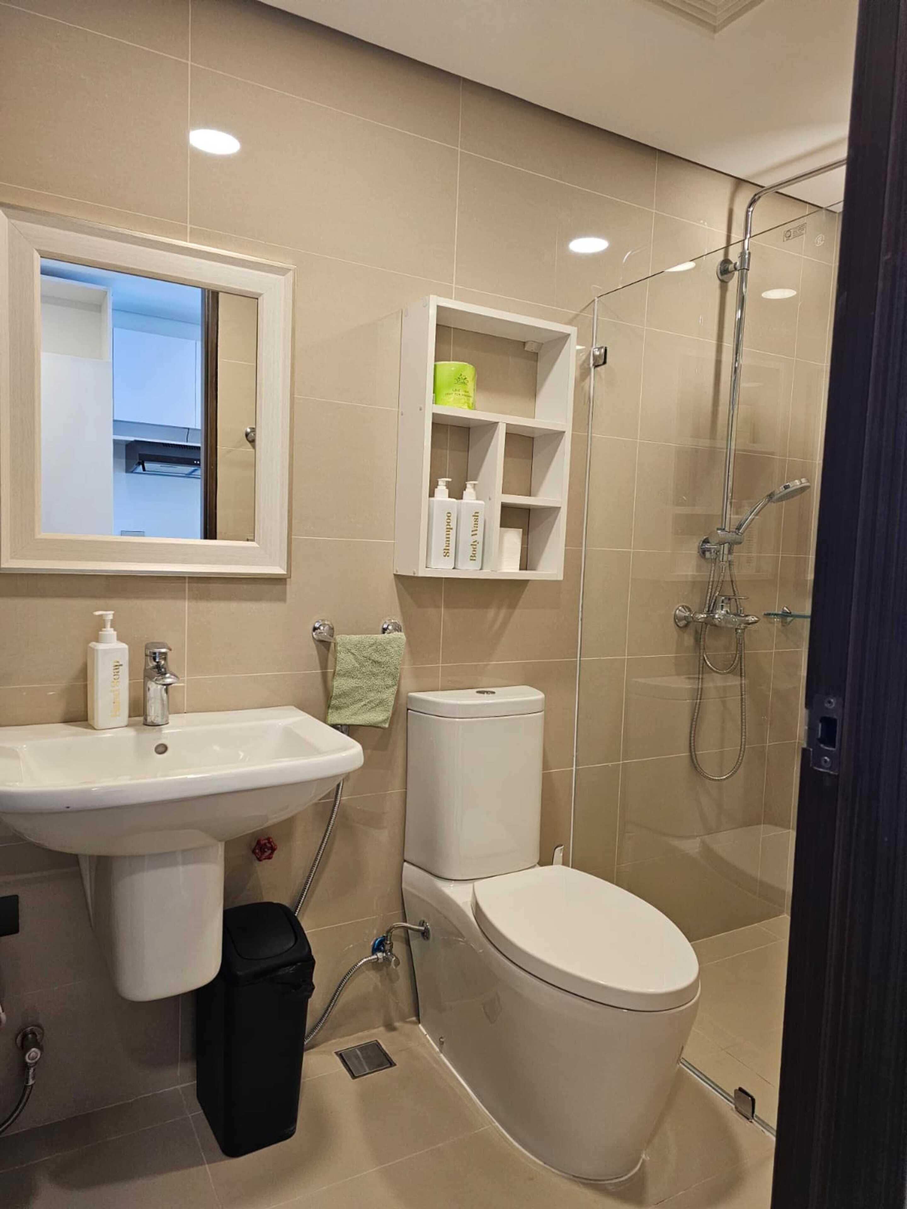 A modern bathroom with a sink, toilet, and shower.