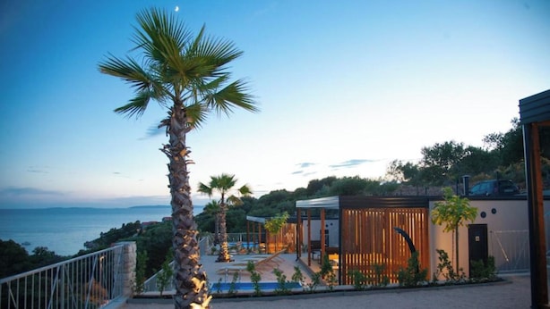 A modern villa with a pool, palm trees, and a view of the sea. - Lastura Mobile Homes (Novalja)