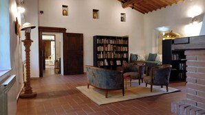 Ein gemütliches Wohnzimmer mit Kamin, Bücherregal und bequemen Sitzmöglichkeiten.