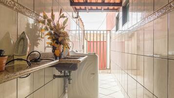 Kitchen with a view, featuring a tiled floor, a window, and a potted plant.