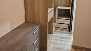 A walk-in closet with wooden cabinetry, a built-in shelf, and a mirrored closet door. - Quiet, small house in the hills above Toulon, close to all amenities. (LE REVEST LES EAUX)