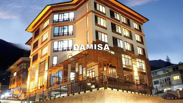 A multi-story building with the name "DAMISA" prominently displayed, featuring balconies and large windows.