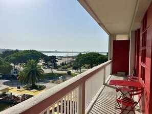 A balcony with a view of a cityscape, including a bridge and trees. - Family apartment in Royan city center, 6/8 people, elevator (Royan)