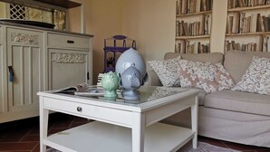 A living room with a white coffee table, a sofa, a bookshelf, and a cabinet.