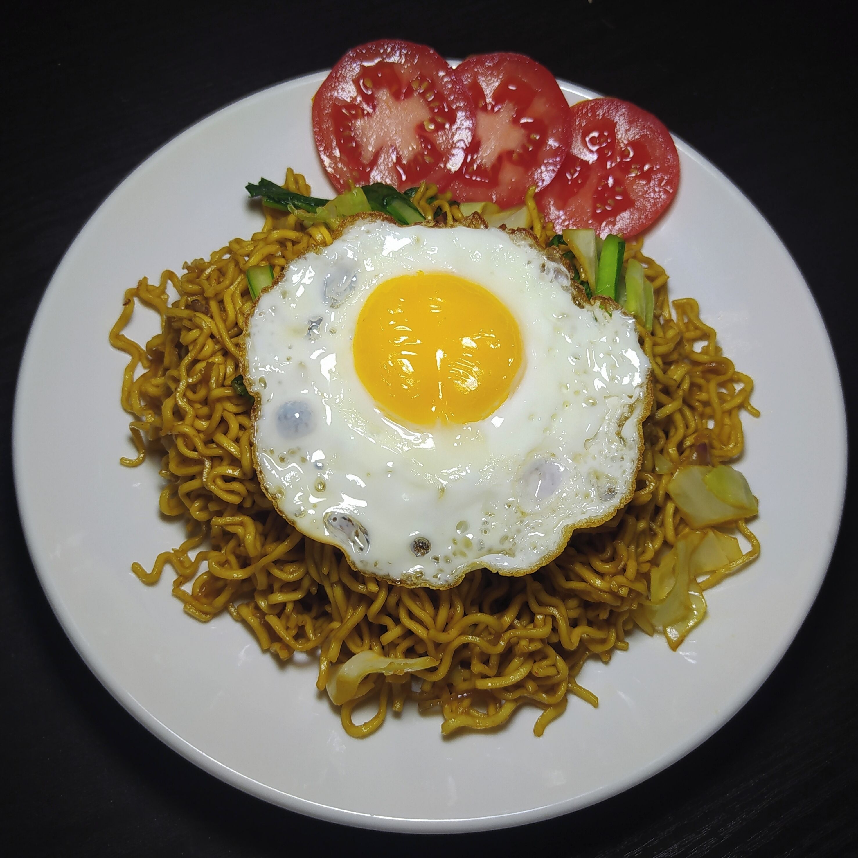 Un plat de fideus coberts amb un ou de trufa i làmines de tomàquet.