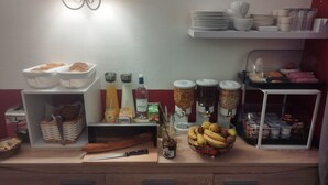 Una encimera de cocina con diferentes alimentos, utensilios y condimentos.