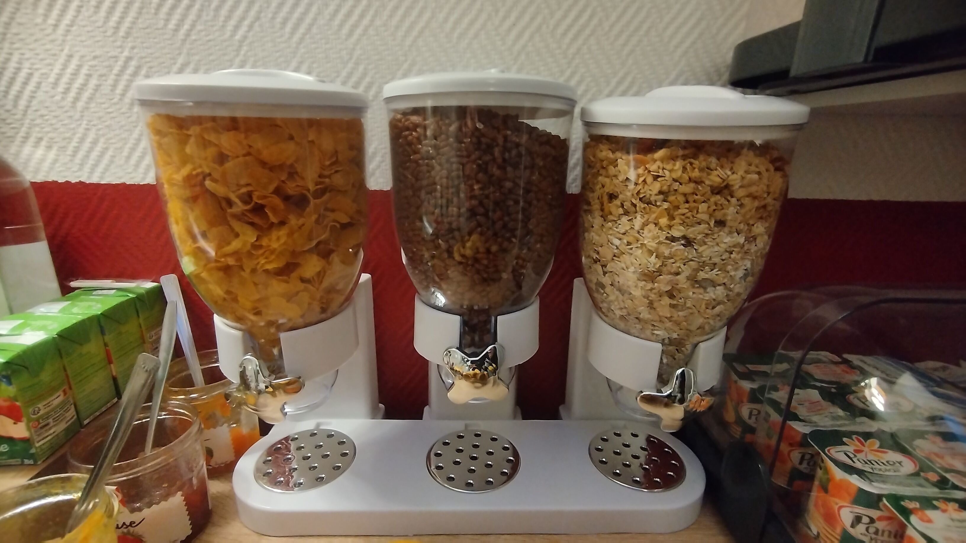 Três distribuidores de comida com conteúdos diferentes sobre um balcão.