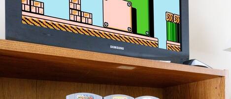 A wooden shelf with a retro video game console and controllers.