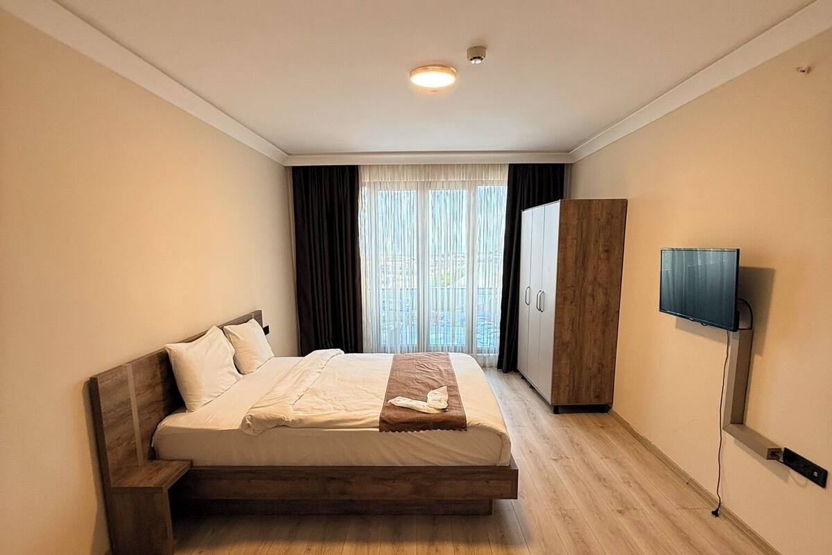 A bedroom with a bed, a TV, and a wardrobe.