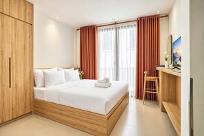 A modern hotel room with a wooden bed, a desk with a chair, and a large window with curtains. - Mihn Suites Ben Thanh (Ho Chi Minh City)