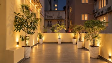 Una terrazza sul tetto con piante in vaso e illuminazione soffusa.